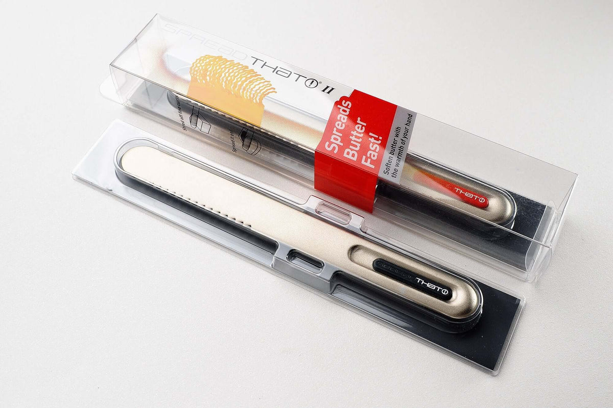 SpreadTHAT! butter knife with packaging, featuring superconducting core for easy butter spreading and serrated edge for fine curls.