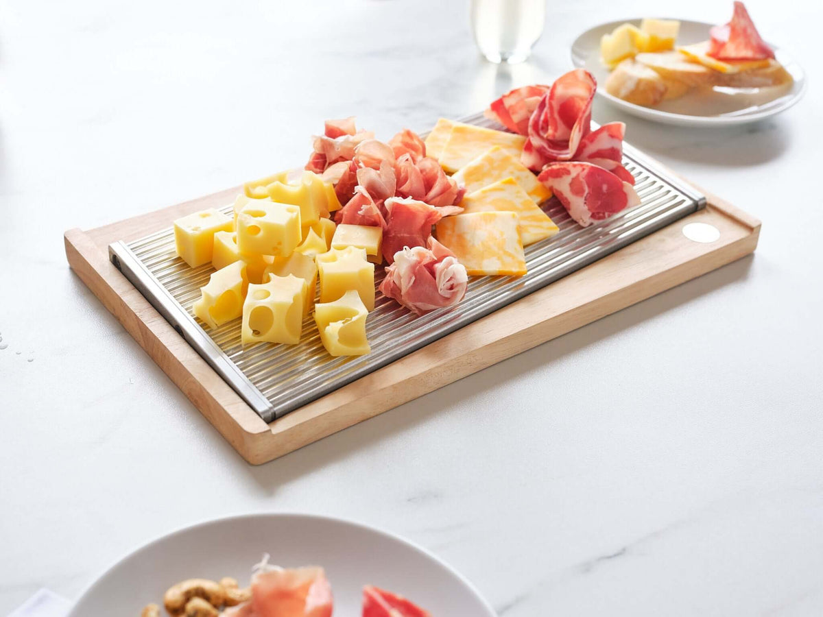ChillTHAT! Platter with cheese and cured meats, made from antimicrobial aluminum, keeps food chilled for 60 minutes using cold plate technology.