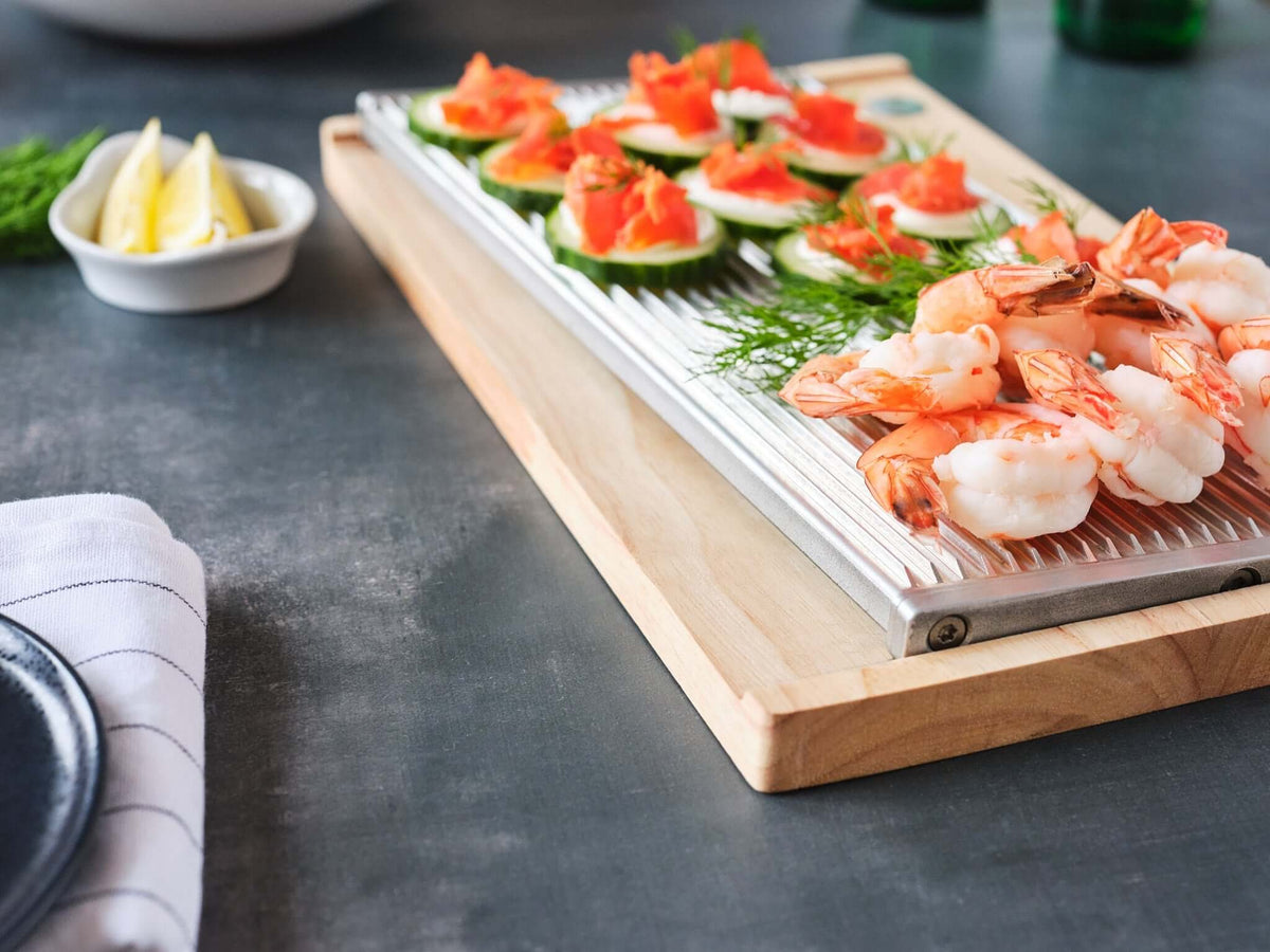 ChillTHAT! Platter with shrimp and cucumber appetizers, showcasing its refreezable aluminum design for keeping food chilled and fresh.